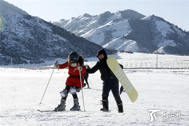 在白云国际滑雪场内,一位初学者在同伴的搀扶下学习滑雪。
