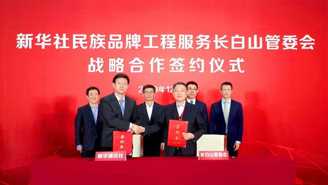 新华社新闻信息中心主任储学军(前左)与长白山党工委委员、管委会副主任王鹏飞(前右)代表双方签署战略合作协议。
