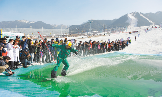 上图为3月24日，在丝绸之路国际度假区滑雪场，滑雪爱好者在体验雪地滑水。