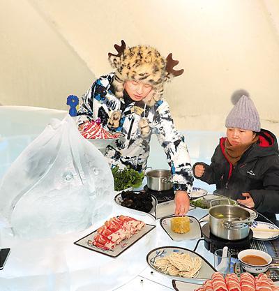 游客在哈尔滨冰雪大世界园区“冰屋”品味“冰火锅”