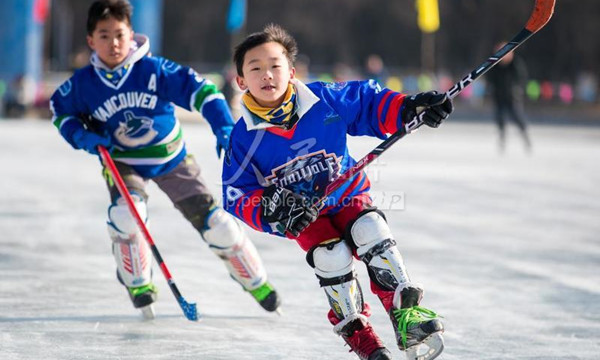 在内蒙古自治区呼和浩特市的公园冰场里，小朋友在进行冰球训练