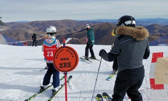 崇礼太舞滑雪场，小滑雪者在教练的带领下即将从高级道滑下。