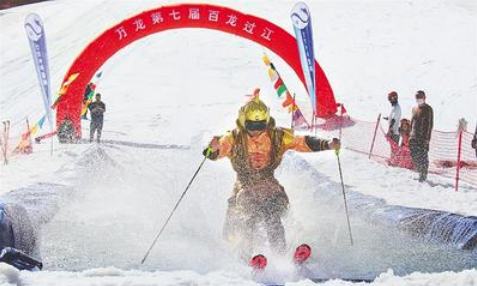 5月1日，万龙滑雪场第七届“百龙过江”活动现场，一名选手滑过水池。