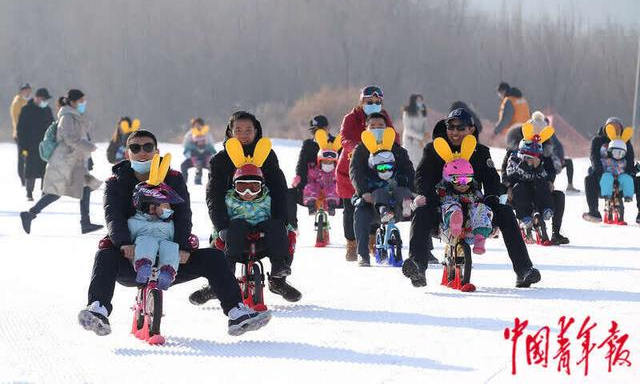 北京平谷渔阳国际滑雪场，家长们带着孩子骑着滑步车滑雪