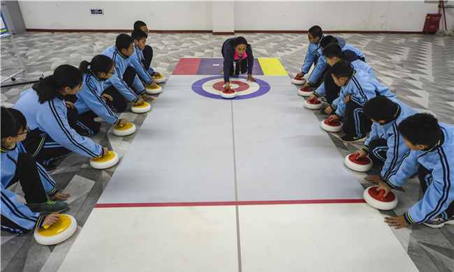 在河北省衡水市第三中学，教练在给学生们讲解陆地冰壶的动作要领