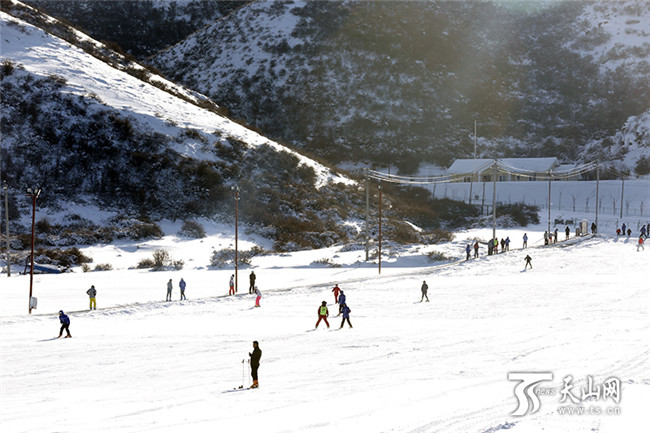 在白云国际滑雪场内，滑雪爱好者们正在初级道上感受冰雪带来的乐趣。